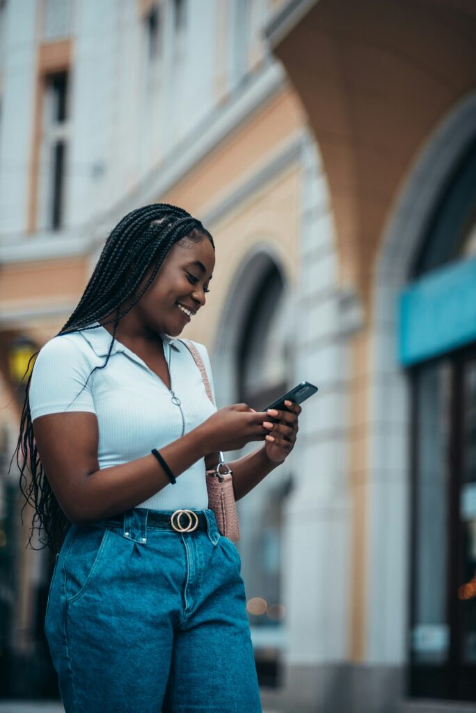 Cheerful african american woman using smartphone