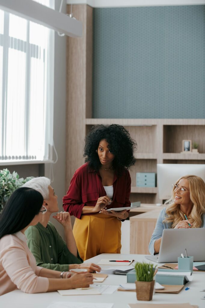Group of mature women communicating while having business meeting in office